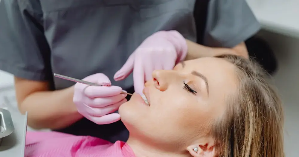 Uma paciente recebe um exame dental por um dentista em uma clínica.